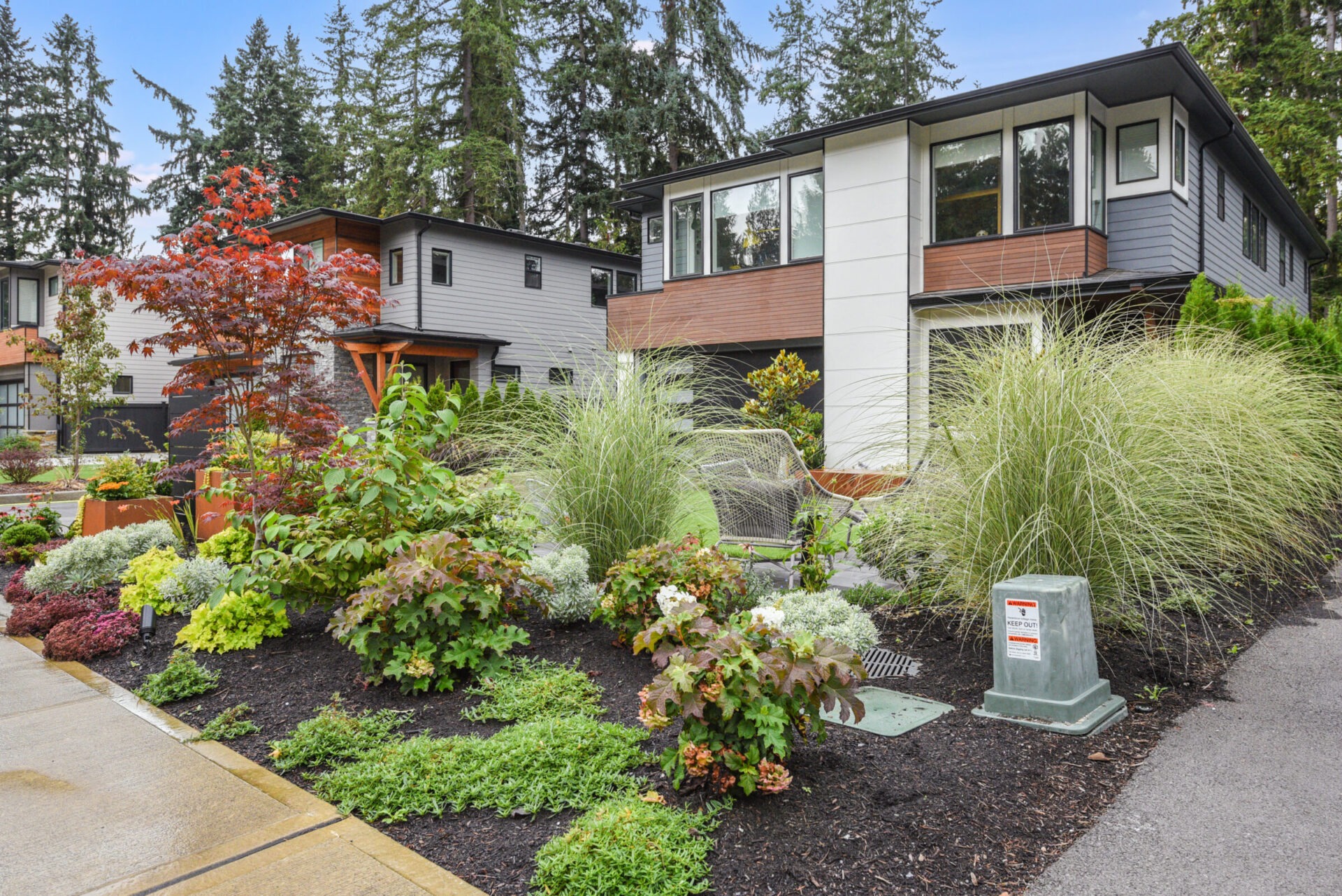 Modern homes in a suburban neighborhood, surrounded by lush greenery and landscaped gardens. No recognizable landmarks or historical buildings present.