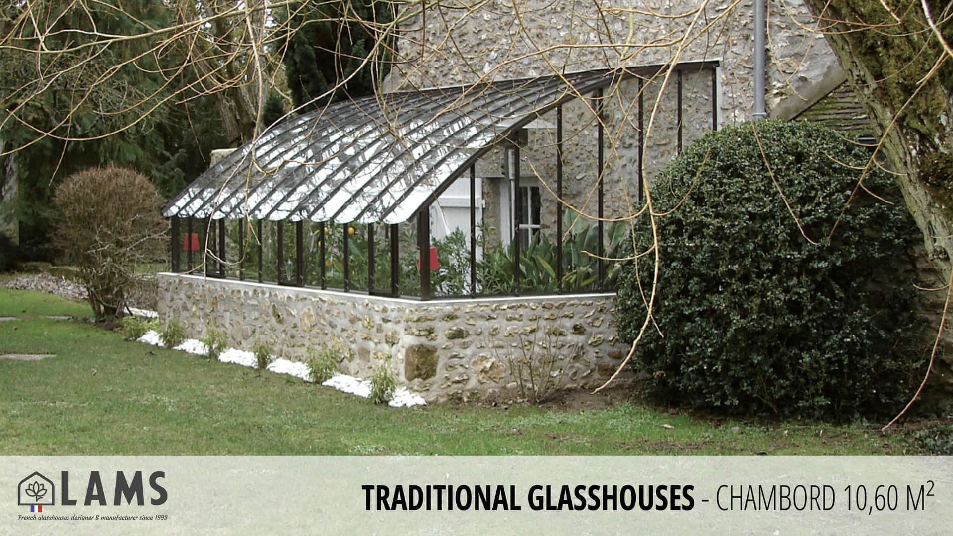 Stone building with a traditional glasshouse attached. Surrounded by greenery and neatly arranged white flowers. LAMS branding and description visible.