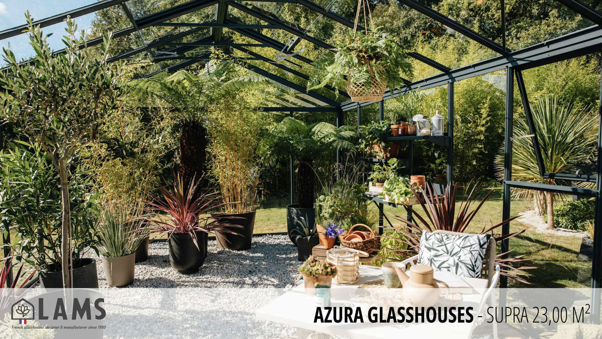 A modern glasshouse filled with diverse plants and decorative items, featuring a lush garden background and stylish outdoor seating.