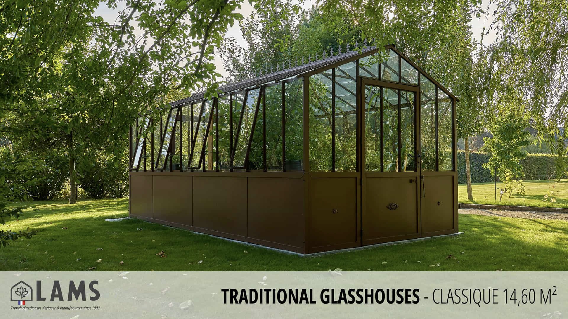 A traditional Classique 14.60 m² glasshouse is centered in a lush garden, surrounded by trees and greenery. LAMS branding displayed.